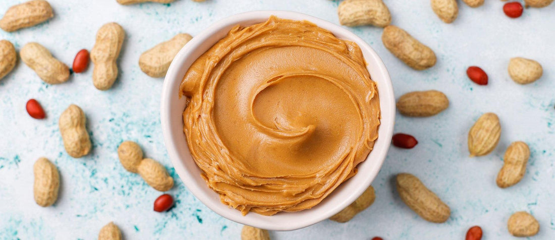 A bowl of butter surrounded by various nuts